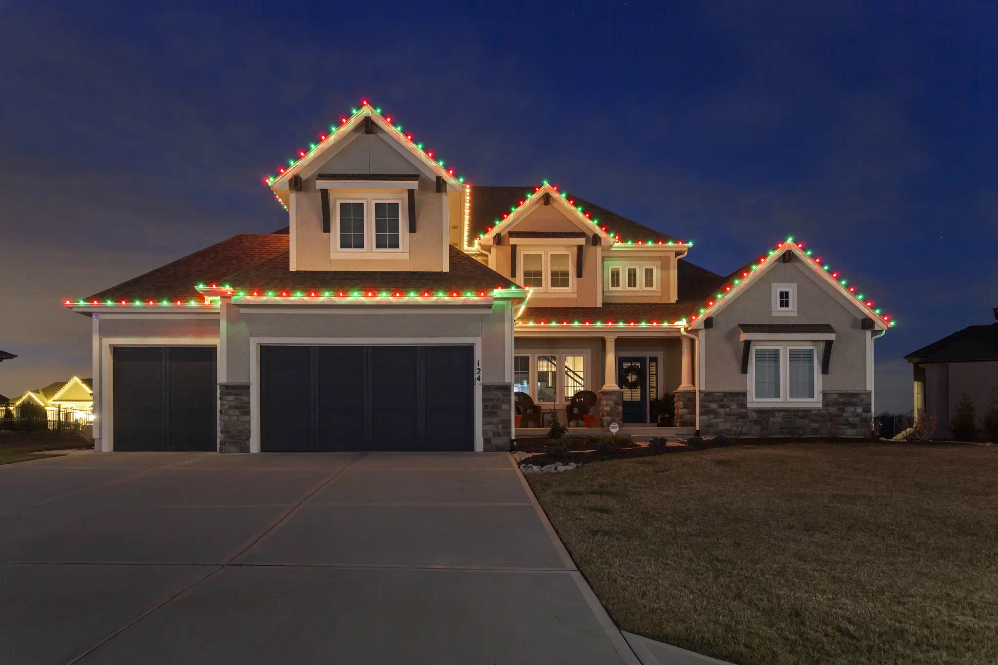 Two-story home with red and green C9 lights along the rooflines and eaves